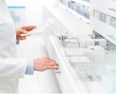 Pharmacist opening drawer filled with painkillers